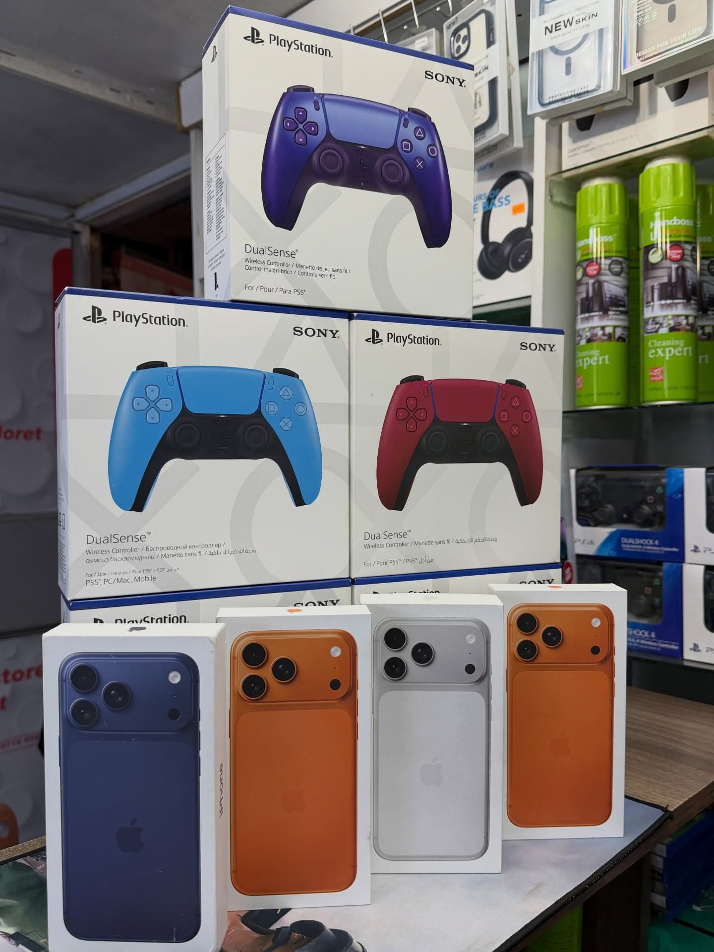 PlayStation controllers displayed above boxed iPhones in store